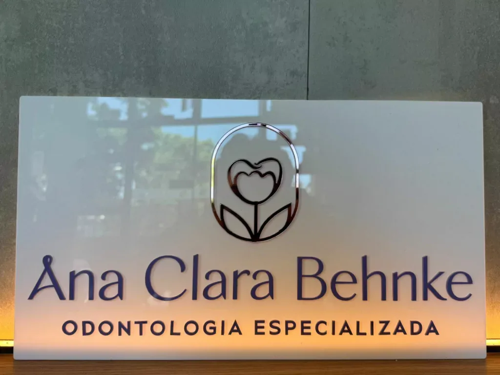 Sinalização em acrílico na porta de vidro de uma clínica